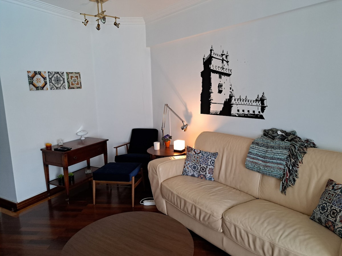 Bright lounge with a sofa, artwork and wooden floors