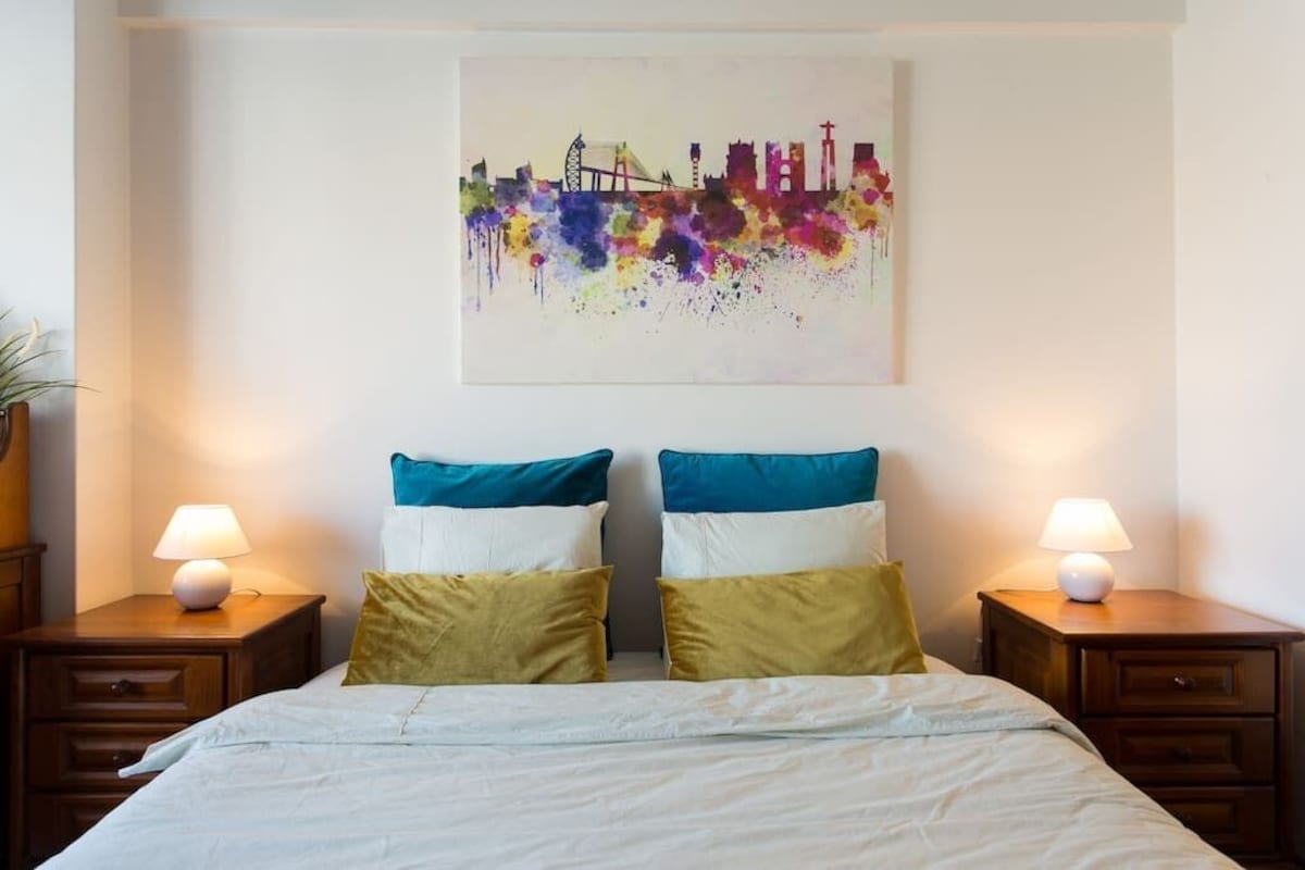 Main bedroom with a double bed and colourful Lisbon artwork
