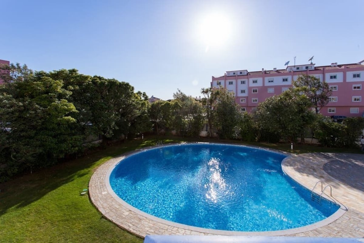 Shared condominium swimming pool surrounded by lawns